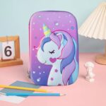 Purple pencil case with a unicorn design on a pink surface with stationery items.