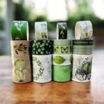 Green Botanical Washi Tape Set - 18 RollsDecorative Washi TapeCRAFTY CUDDLESet of green - themed washi tape rolls on a wooden surface with a blurred natural background.washitape washitapelove washitapeaddict botanicalstationery natureinspired greenaesthetic journaling junkjournal artjournaling scrapbooking creativejournaling aestheticstationery stationerylovers