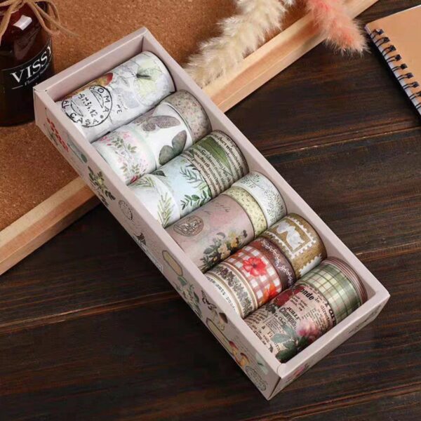 Set of washi tape rolls in a decorative box on a wooden surface