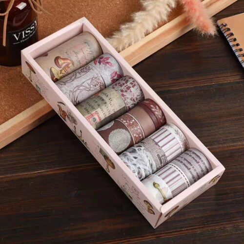Set of washi tape rolls in a decorative box on a wooden surface