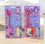 Two packages of cartoon bear-themed stationery items on a wooden surface.