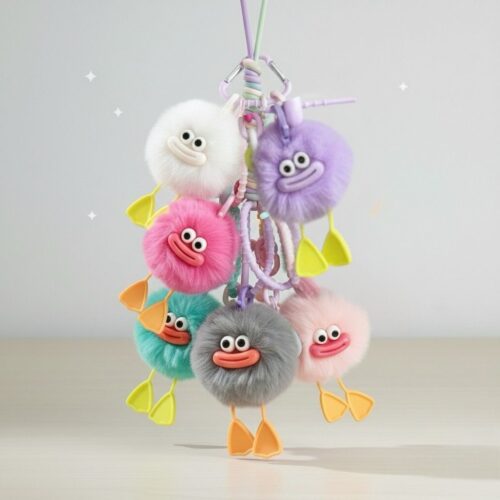Colorful plush keychain with cartoonish faces on a light gray background