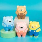Four colorful bear sharpeners with polka dot overalls on a blue background