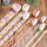 Multi - Design Washi Tape Set – 50 RollsDecorative Washi TapeCRAFTY CUDDLEDecorative tape rolls with various patterns on a wooden surface