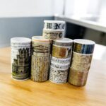 Vintage Text Washi Tape Set - 18 RollsDecorative Washi TapeCRAFTY CUDDLERolls of decorative tape with various designs stacked on a wooden surface.Past Events Boxwashitape washitapelove washitapeaddict vintagestationery retrostationery newspaperstyle journaling junkjournal scrapbooking artjournaling creativejournaling aestheticstationery stationerylovers