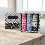 Set of washi tape rolls in a decorative box on a stone surface.