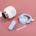 Stainless Steel Wide Mouth Water BottleTumblersCRAFTY CUDDLEWhite water bottle with blue cap, straw, and carrying strap on a pink backgroundSky BlueStainlessSteelBottle WideMouthBottle InfuserBottle ReusableStraw TravelWaterBottle GymWaterBottle LeakproofBottle DetoxWaterBottle PortableBottle EcoFriendlyLifestyle