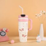 1000ml Stainless Steel Insulated TumblerTumblersCRAFTY CUDDLEPink insulated tumbler with handle on a beige backgroundPinkInsulatedTumbler StainlessSteelMug TravelTumbler 1000mlBottle VacuumFlask HotAndColdBottle BPAFree CoffeeOnTheGo CarCupHolderFriendly ReusableDrinkware
