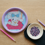 Sanrio Theme DIY Diamond Painting Coaster KitDIY KitsCrafty CuddleDIY kit with cartoon character design on a wooden table with beads and a pen.
