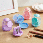 Rocket Blast Pencil SharpenerCrafty CuddleSet of colorful pencil sharpeners on a wooden surface with pencils and a sharpener.1