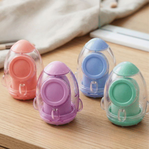 Four colorful plastic sharpeners on a wooden surface