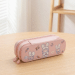 Double Layer Cartoon Pencil PouchPencil PouchCrafty CuddlePink pencil case with cartoon designs on a wooden surfacePeachpencilpouch cutestationery kidsstationery cartoonpencilcase doublelayerpencilcase schoolstationery stationeryforkids cuteaccessories backtoschool kawaiistationery