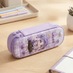 3D Cartoon Double Layer Pencil PouchPencil PouchCrafty CuddlePurple cartoon - themed pencil case on a wooden desk with stationery items.Purplepencilpouch 3dpencilcase kidsstationery doublelayerpencilcase cartoonpencilpouch schoolstationery stationeryforkids cutestationery backtoschool studentstationery