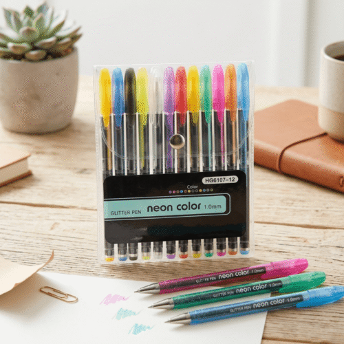 Pack of neon color glitter pens on a desk with a plant and notebook in the background