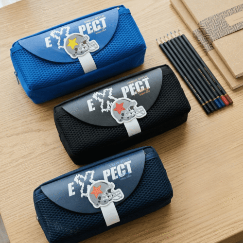 Three blue pencil cases with 'PECT' branding on a wooden surface.