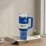 Stanley TumblerDrinkwareCrafty CuddleBlue Stanley tumbler with a straw on a wooden surface with a plant in the backgroundStanley Tumbler-3BlueAestheticVibesAmazonFinds