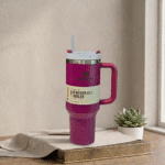 Purple tumbler with handle on a wooden surface with a plant in the background