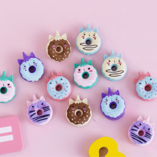 Colorful donut-shaped erasers with animal faces on a pink background