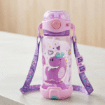 Children's water bottle with purple dragon design and strap on a light surface.
