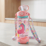 Children's water bottle with unicorn design and colorful strap on a light surface.