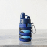 Silicone Collapsible Sipper BottleSilicone Water BottleCrafty CuddleCollapsible blue water bottle with carabiner on a light backgroundSilicone Bottle BlueBlueBPA free bottlecollapsible water bottle