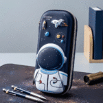 Pencil case with astronaut design on a desk with pens and books