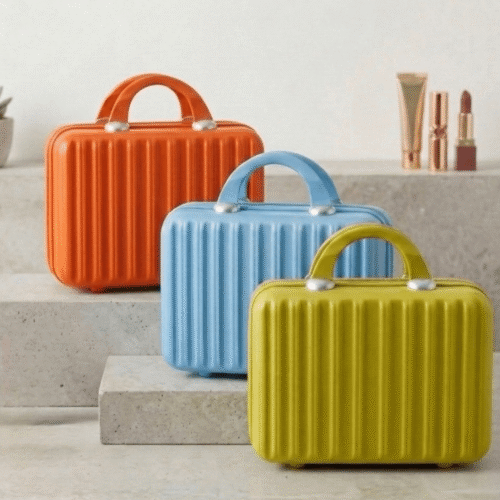 Three colorful makeup cases (orange, blue, yellow) on a neutral background