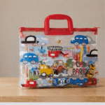 Transparent Kids Document BagKids BagsCrafty CuddleClear bag with colorful car - themed design and red handle on a wooden surface.CarKidsFileBag CartoonStationery KidsOrganizer SchoolSupplies CuteStationery KidsDocumentBag StationeryLovers KidsSchoolEssentials A4FileBag TransparentBag