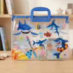 Transparent Kids Document BagKids BagsCrafty CuddleClear plastic bag with blue handle featuring cartoon sharks and sea creatures on a wooden surface.SharkKidsFileBag CartoonStationery KidsOrganizer SchoolSupplies CuteStationery KidsDocumentBag StationeryLovers KidsSchoolEssentials A4FileBag TransparentBag