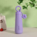 Stainless Steel Water Bottle with HandleCartoon Kids Water BottleCrafty CuddlePurple water bottle with a flower - shaped keychain on a light green backgroundPurple