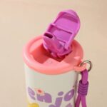 Cartoon Print Leakproof FlaskCartoon Kids Water BottleCrafty CuddleChildren's cup with pink lid and purple handle on a beige backgroundCreamKidsWaterBottle SchoolEssentials CartoonBottle StainlessSteelBottle LeakproofBottle KidsAccessories BackToSchool CuteStationery InsulatedBottle KidsHydration