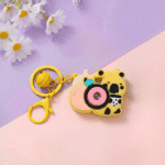 Cute Camera Shape Projector KeychainKeychainsCrafty CuddleYellow keychain with camera design on a pink and purple backgroundYellowCuteKeychain KawaiiAccessories KidsAccessories ReturnGiftIdeas CartoonKeychain MiniCamera BagCharm StationeryLove GiftForKids TrendingNow