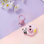 Cute Camera Shape Projector KeychainKeychainsCrafty CuddlePink panda - themed camera - shaped keychain on a two - tone purple and pink background with white flowers.PinkCuteKeychain KawaiiAccessories KidsAccessories ReturnGiftIdeas CartoonKeychain MiniCamera BagCharm StationeryLove GiftForKids TrendingNow