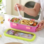 Leakproof Bento Box with Spoon ForkStainless Steel Lunch BoxCrafty CuddlePerson opening a pink bento box with compartments filled with food on a white table.Dinosaur