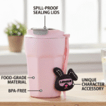 Pink tumbler with a character accessory on a wooden surface, labeled for features.